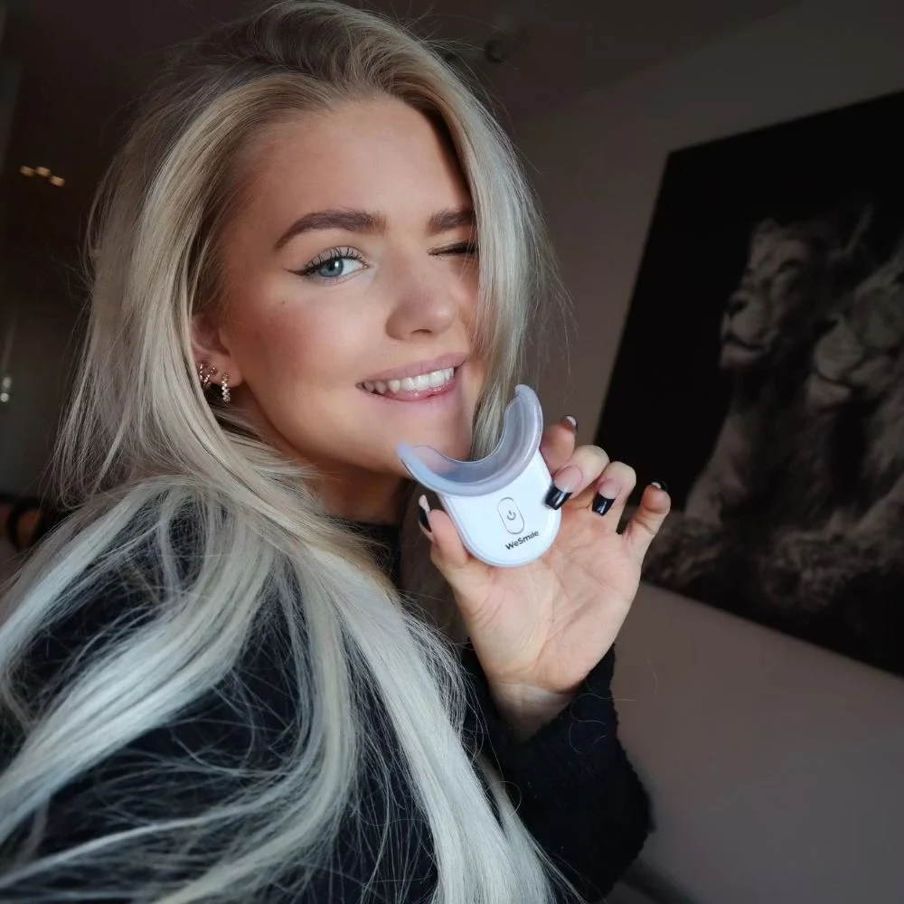 Holder LED-boosteren med skinnen opp mot smilet